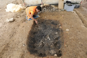 Verkohlte Holzreste werden freigelegt, freigekratzt