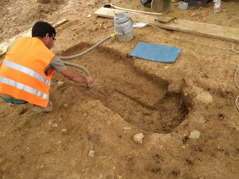 Grab wird freigelegt mit Staubsauger