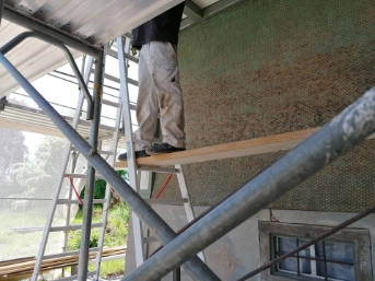 Ansicht der Baustelle mit Gerüst und Planen  auf dem Bauernhof