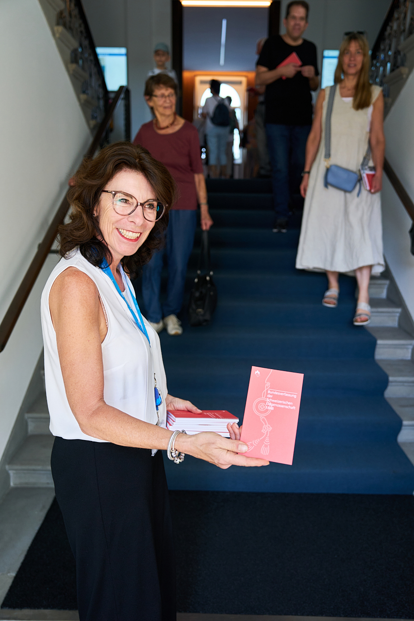 Evelyne Daseler, Stv. Standesweibelin, überreicht die Bundesverfassung.